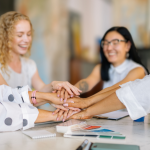 Mujeres estrechando la mano en un entorno profesional, representando colaboración en proyectos de economía social en Asturias